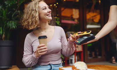 A woman pays for a coffee using her digital wallet