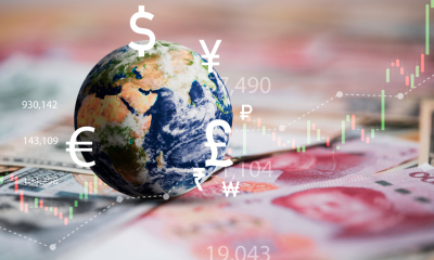 A globe is sitting on top of a file of foreign currency