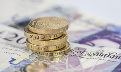 5 pound coins lying on top of multiple £20 notes