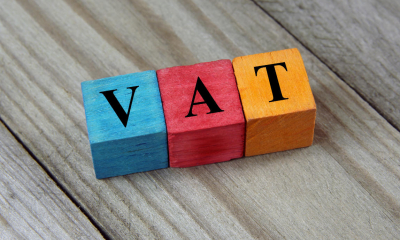 Three multicoloured wooden blocks with 'VAT' written on them