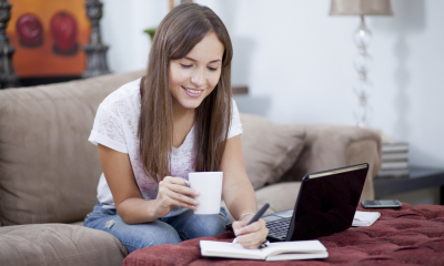 Woman sat on a sofa holding a mug while claiming self-employed home expenses