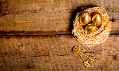 A nest on a table containing three golden eggs