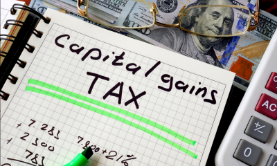 Notebook with 'Capital gains TAX' written in black with various items around it